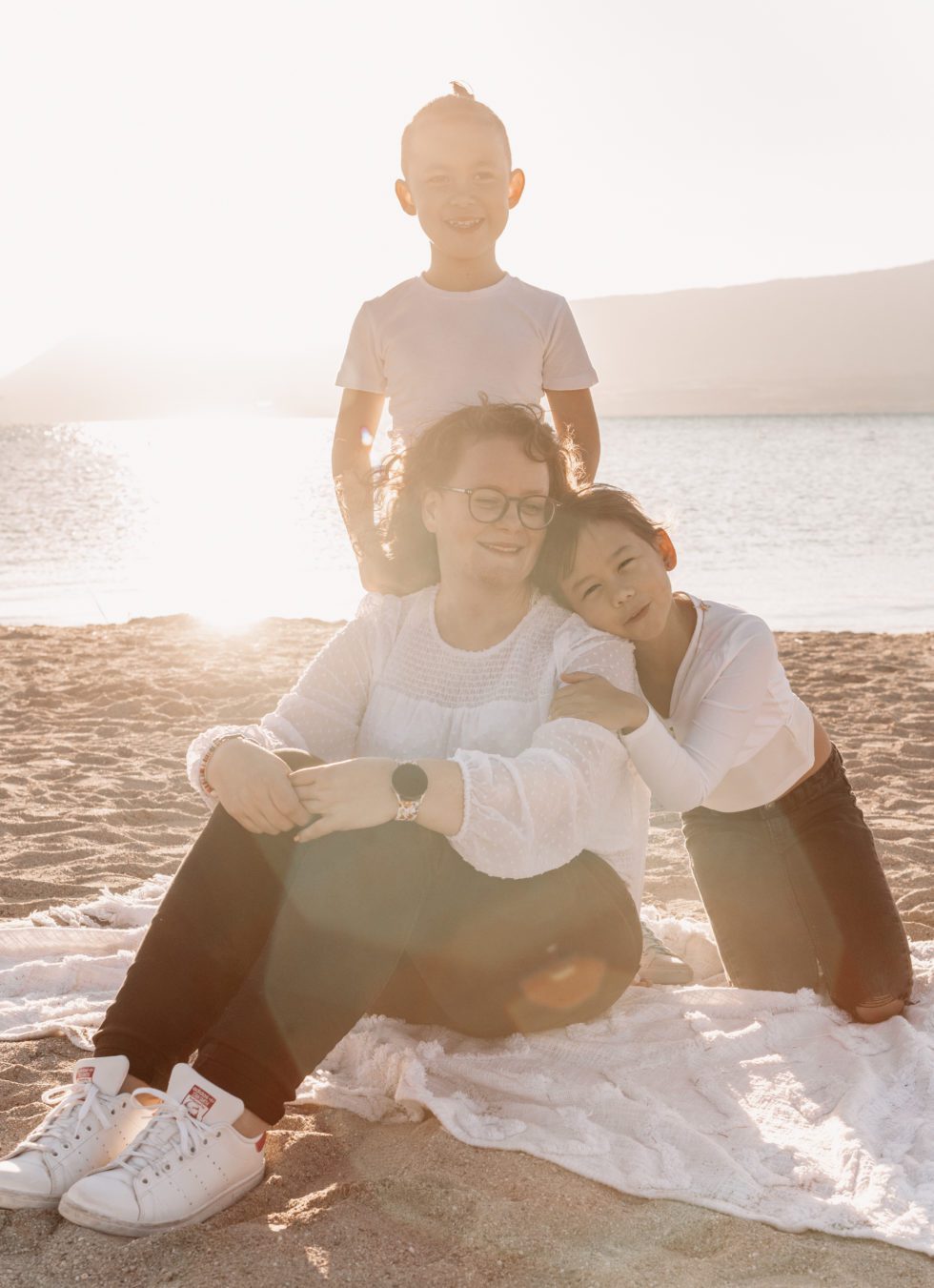 Famille sur le sable avec le sourir